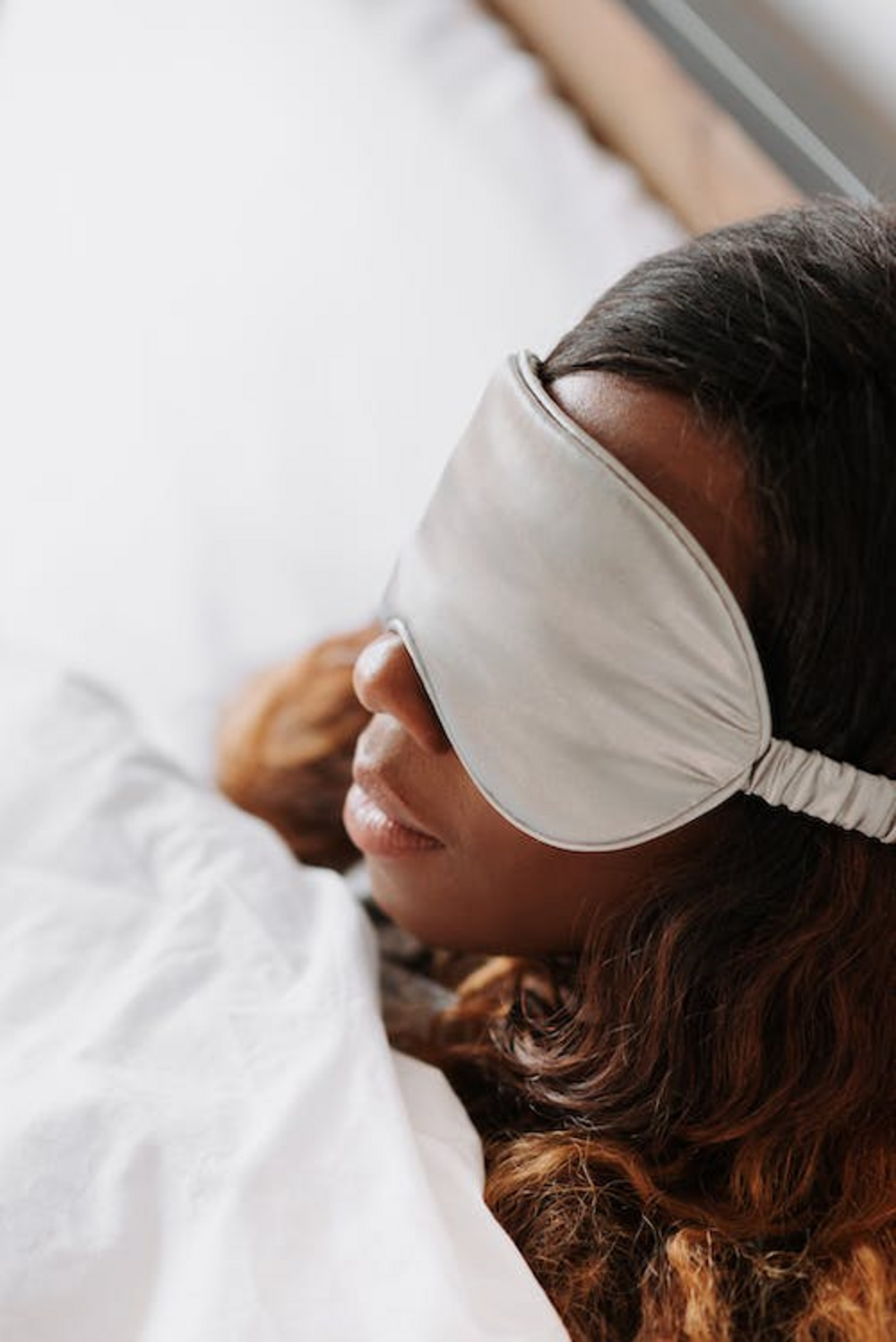 A person sleeping with an eye mask