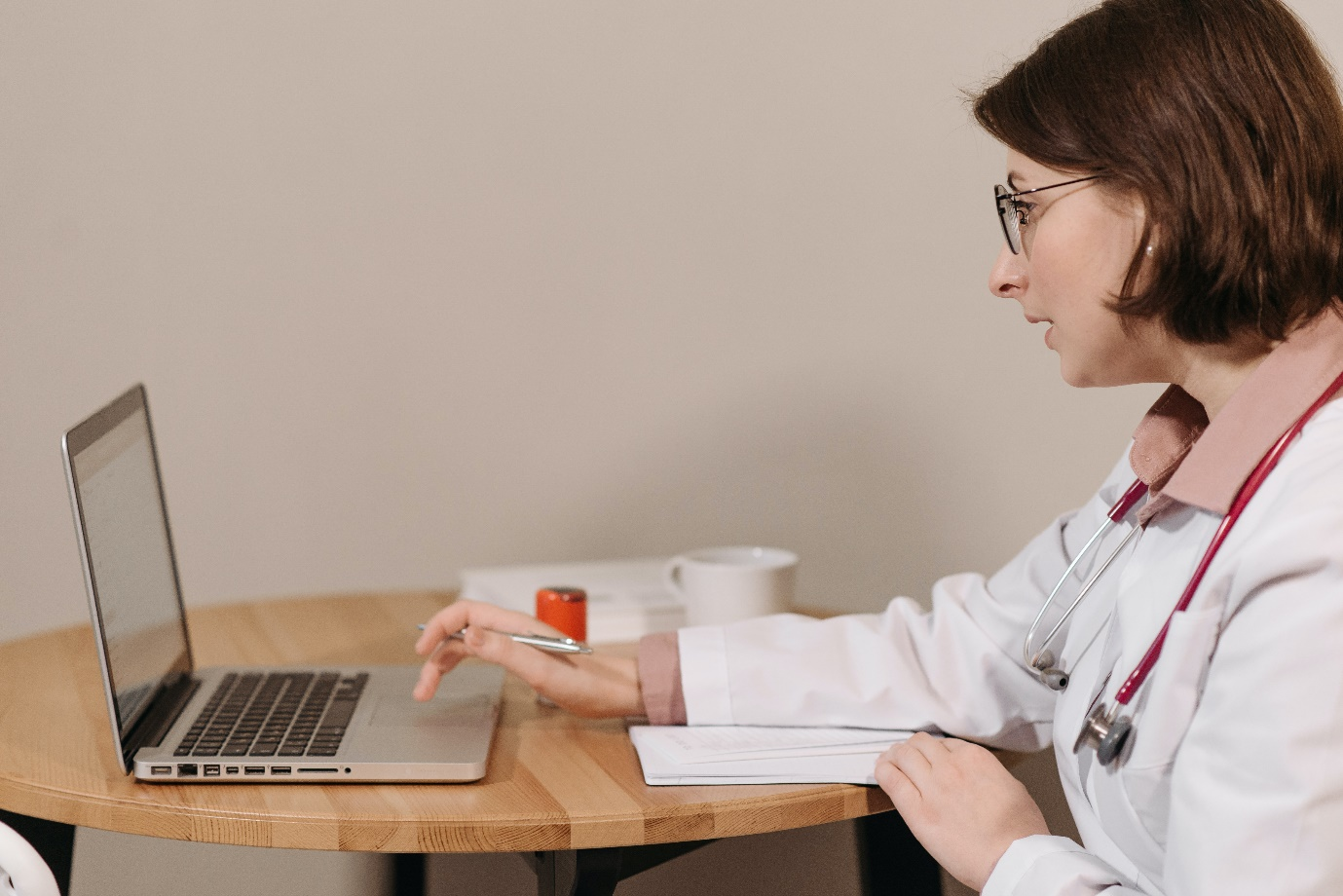A doctor using her laptop for an online prescription for a patient
